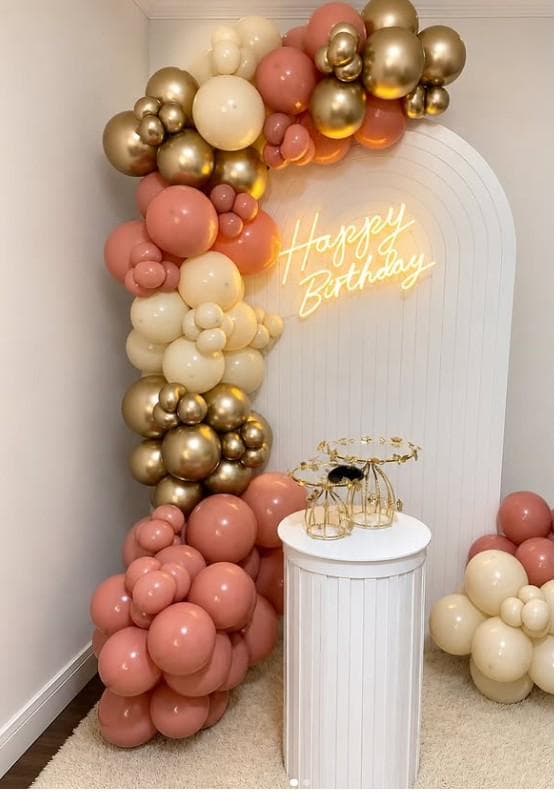Arco de globos en tonos pastel rosado, crema y dorado