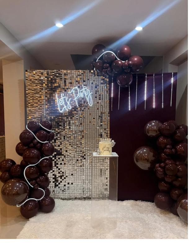 Decoración en negro y plata con letrero de neón Let's Party